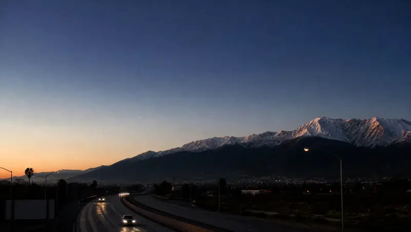 Snow-capped San Bernardino Mountains catch first light above the 91 freeway in Riverside at dawn.