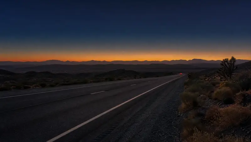 The 14 freeway runs through high desert scrub and Joshua trees toward the Antelope Valley at sunset.